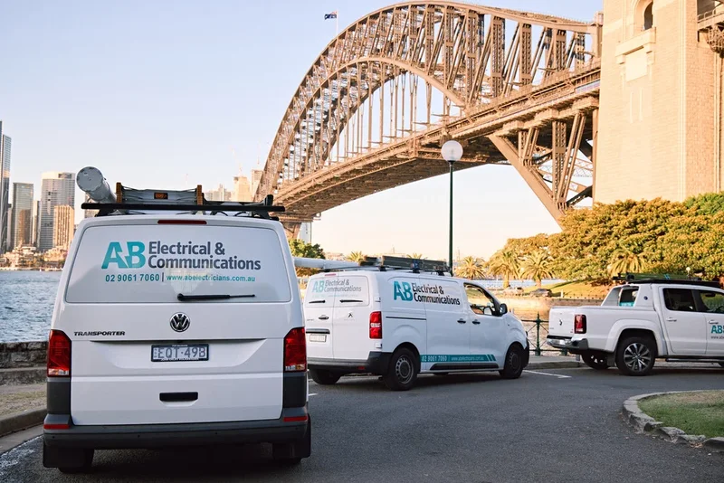 AB Electricians fleet of vans parked under the Sydney Harbour Bridge